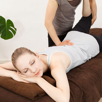 Young woman laying on a massage table while undergoing a massage therapy treatment